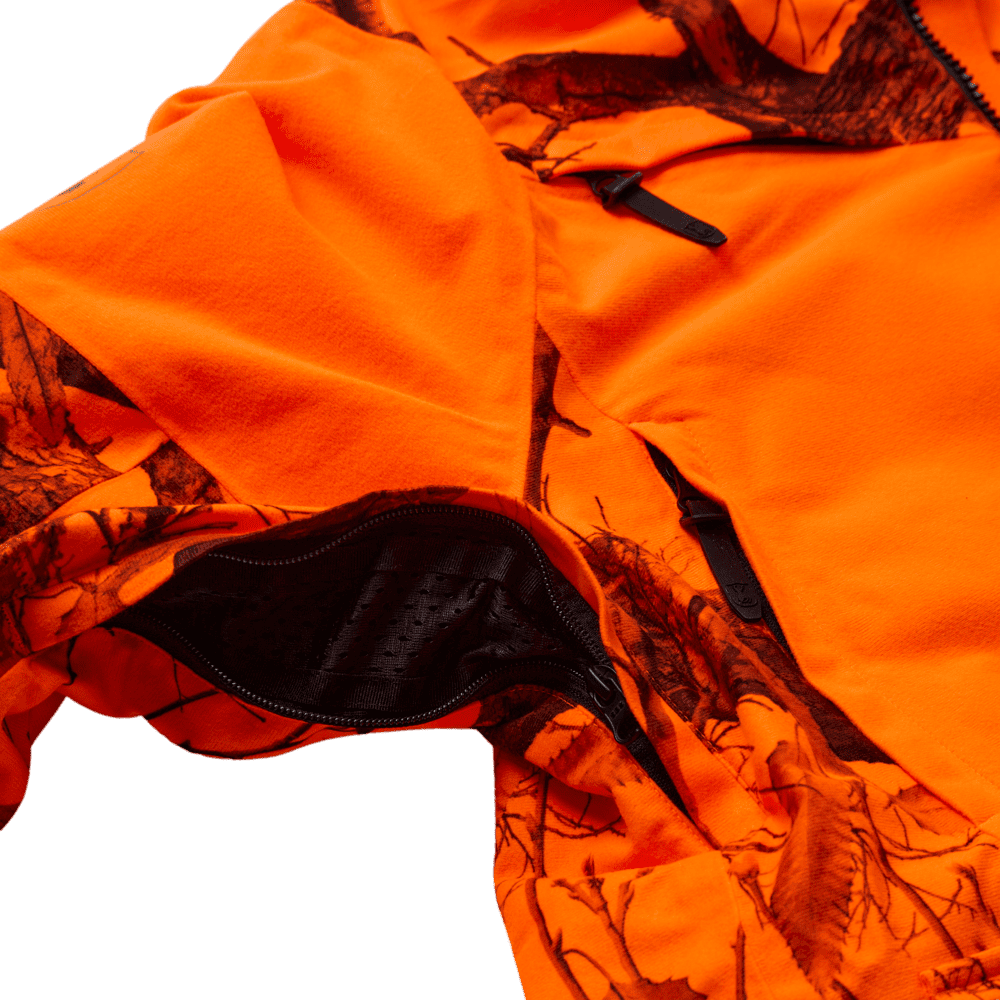 Detailansicht einer signalorangenen Camouflage-Jagdjacke mit geöffnetem Belüftungsreißverschluss (Unterarmbelüftung) und Mesh-Einsatz. Funktionale Drückjagdbekleidung für Herren und Damen für optimale Temperaturregulierung bei der aktiven Jagd im deutsche