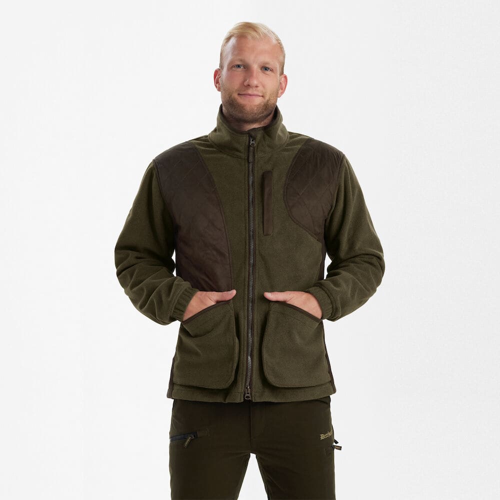 Deerhunter Gamekeeper Shooting Jacke im Tragebild mit gepolstertem Schulterbereich, großen Fronttaschen und Stormliner® Membran für Jagd und Schießsport