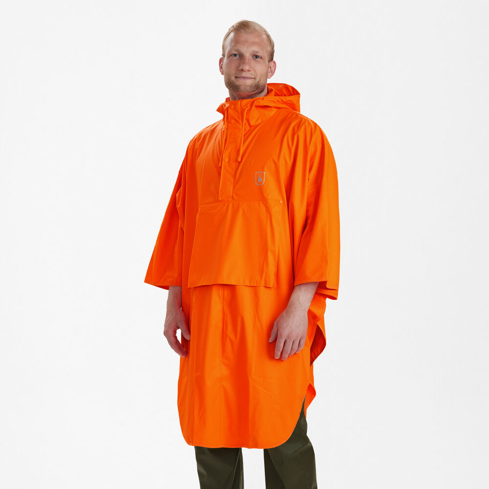 Schrägansicht des getragenen Deerhunter Hurricane Regenponchos in Signalorange mit Kapuze und weiter Passform für optimalen Wetterschutz bei Jagd und Outdoor